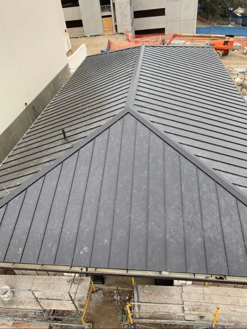 Commercial metal roof construction with crane equipment in Albany